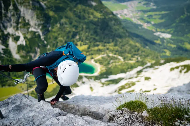Die Frau klettert hoch auf den Felsen. Hübscher Klettersteig, Klettersteig, Klettersteig, Klettersteig. Vom Berg Tajakopf bei Leermos ehrwald austria alps mitgenommen