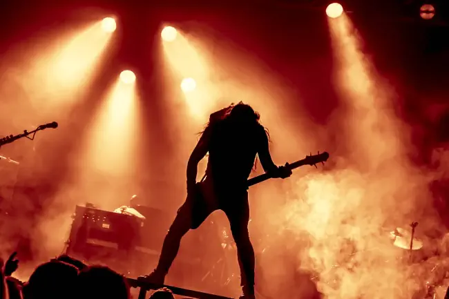Metal Konzert mit Silhouette des Gitarrenspielers in Aktion auf der Bühne