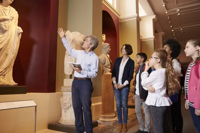 Schüler und Lehrer auf Schulreise zum Museum mit Führer